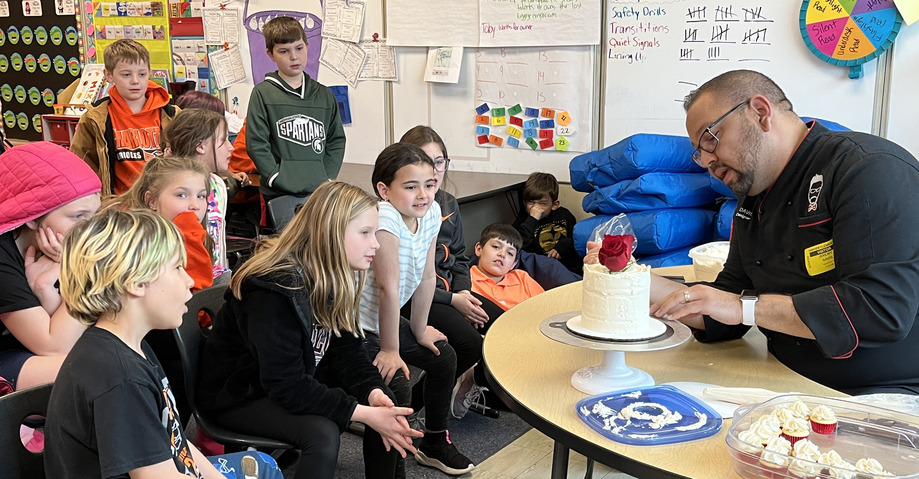 Students learn from a guest cake decorator on career day